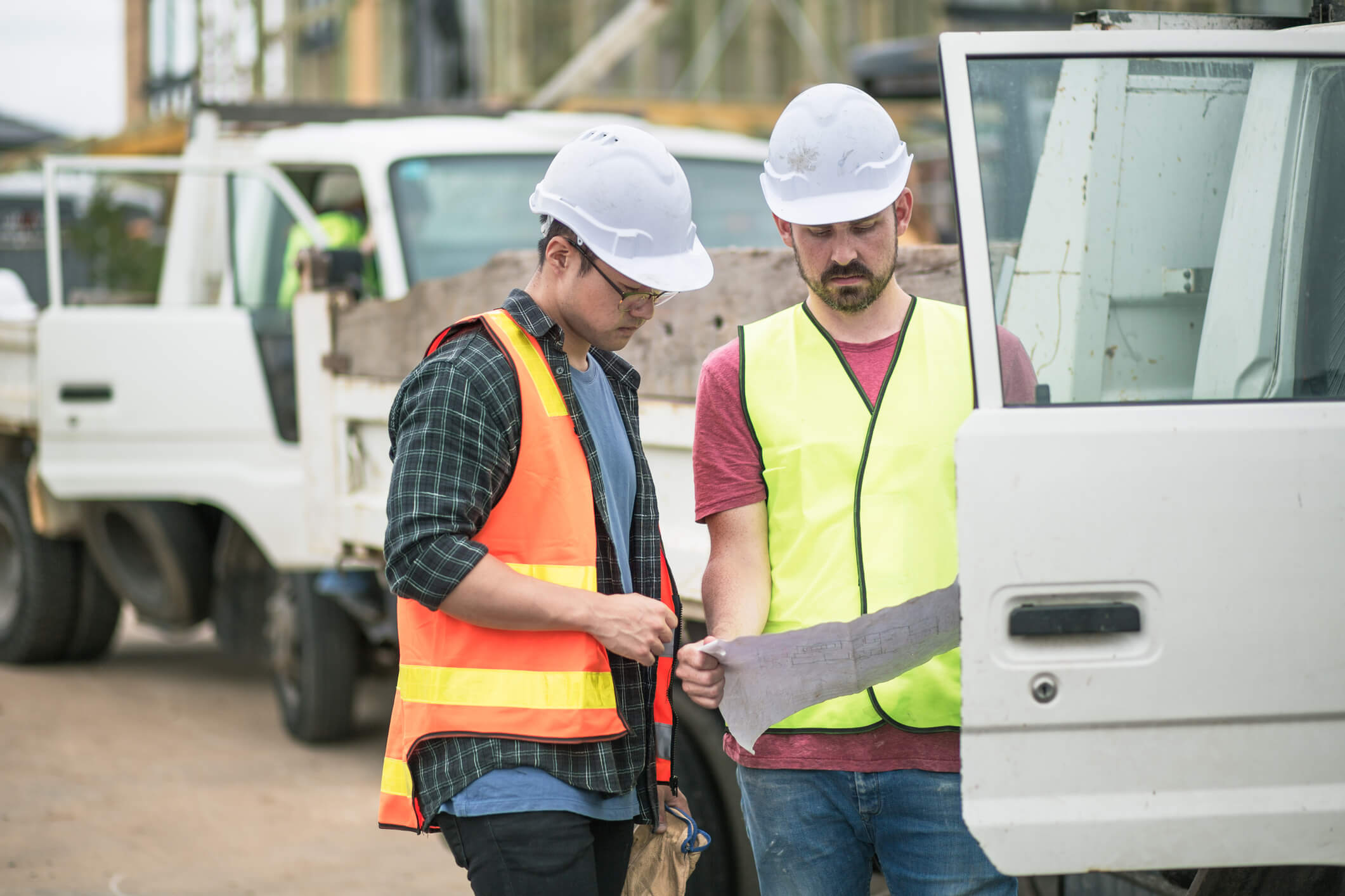 two construction workers reviewing schematics